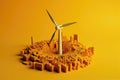 Windmill surrounded stacks of coins on yellow background. Return on investment on Wind energy