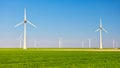 Windmill turbines at sea seen from a drone aerial view from above at a huge windmill park