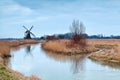 Windmill in winter by frozen river