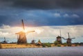 Windmills against cloudy sky at sunset in Kinderdijk, Netherland Royalty Free Stock Photo