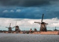 Windmills against cloudy sky at sunset in Kinderdijk, Netherland Royalty Free Stock Photo