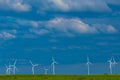 Windmills in a green field against a blue sky.Wind generator in green grass.renewable energy.Alternative energy sources Royalty Free Stock Photo