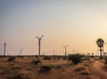 Windmills leading with rural road in morning Royalty Free Stock Photo