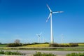 Windmills, Many wind turbines standing on field with lush green grass in spring, alternative energy sources. Royalty Free Stock Photo