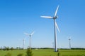 Windmills, Many wind turbines standing on field with lush green grass in spring, alternative energy sources. Royalty Free Stock Photo