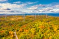 The Windmills park of Paldiski. Wind turbine farm near Baltic sea. Autumn landscape with windmills, orange forest and blue sky. Royalty Free Stock Photo