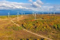 The Windmills park of Paldiski. Wind turbine farm near Baltic sea. Autumn landscape with windmills, orange forest and Royalty Free Stock Photo
