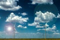 Windmills on the plains with lens flares and dramatic clouds Royalty Free Stock Photo