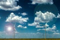 Windmills on the plains with lens flares and dramatic clouds