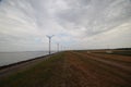 Windmills in a row along a of the IJsselmeer close to lelystat at the Ketelmeer in the Netherlands. Royalty Free Stock Photo