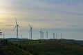 Windmills standing in line on the mountain.