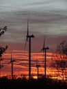 Windmills at sunset over land Royalty Free Stock Photo