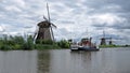 Windmills and tour boat at Kinderdijk Royalty Free Stock Photo