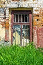 Window of an abandoned old brick house with bars and peeling paint on the frame Royalty Free Stock Photo