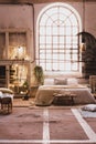 Window above bed with pillows in spacious bright loft interior