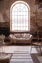 Window above grey wooden settee in spacious living room interior with armchair Royalty Free Stock Photo