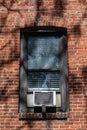 Window Air Conditioner Outside an Old Brick Apartment Building in New York City Royalty Free Stock Photo