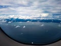 Window airplane plane view grey white dark clouds sky sea ocean coast kuala lumpur airport approach malaysia asia Royalty Free Stock Photo