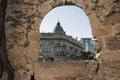 Window in the ancient fortress wall of the old city with modern houses and buildings Royalty Free Stock Photo