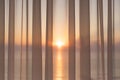 Window of a balcony with transparent curtains and view of morning sun and sea. Concept Royalty Free Stock Photo