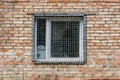 The window behind the iron grate in a brick wall. Royalty Free Stock Photo