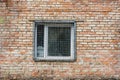 The window behind the iron grate in a brick wall. Royalty Free Stock Photo