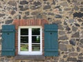 Window with blue clapboard in natural stone facade