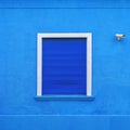 Window on blue facade with dark blue rolling shutters