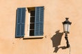 Window with blue shutters and old streetlamp Royalty Free Stock Photo