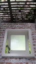 Window on brick show wall under light through roof Royalty Free Stock Photo