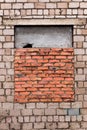 The window is bricked up. Window is laid brick. Gray brick wall with a window laid with red brick. The window is half-closed Royalty Free Stock Photo