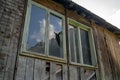 Window with broken glass in old building. Wooden window frame with partially broken glass in old abandoned wooden Royalty Free Stock Photo