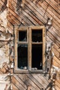 Window with broken glass in a wooden abandoned house