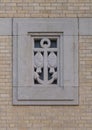 Window with a carved anchor cross and two fish on the outside of Christ the King Church in Dallas, Texas.