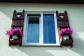 Window with carved doors and with flower pots on the facade of t Royalty Free Stock Photo
