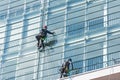 Window cleaners on glass facade of a skyscraper