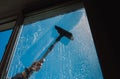 Window cleaner using a squeegee to wash a window outside