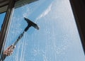 Window cleaner using a squeegee to wash a window