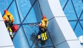 Window cleaner working on a glass facade modern skyscraper