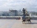 Window cleaning employee with work tools and city background.