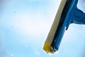 Window cleaning with a mop that cleans glass and blue sky Royalty Free Stock Photo