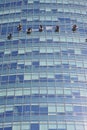 Window cleaning workers hanging outside blue glass office building. Risky job, dangerous work concepts