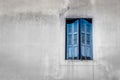 Window with closed blue shutters against a gray wall Royalty Free Stock Photo