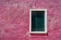 Window with closed green green shutter on bright pink wall. Italy, Venice, Burano Royalty Free Stock Photo