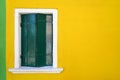 Window with closed green shutter on yellow wall. Italy, Venice, Burano Royalty Free Stock Photo