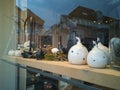 Window of closed interior decor store shelf on Easter.Funny cute ceramic chicken,eggs,spring flowers,decorative element