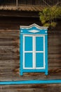 The window with closed shutters is blue and white in the color of an old village house with a sprig of spruce Royalty Free Stock Photo