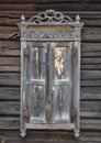Window with closed shutters and decorative wooden elements on the wall of a wooden house Royalty Free Stock Photo