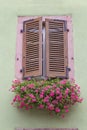 Window with closed wooden shutters on ancient wall Royalty Free Stock Photo