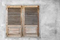 Window with closed wooden shutters. Gray concrete wall background. Royalty Free Stock Photo